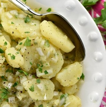 Aerial close-up of Swabian Kartoffelsalat on white plate.