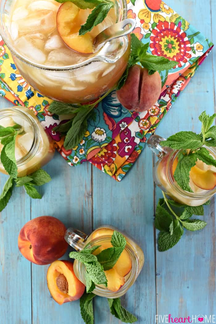 Aerial view of garnished pitcher and glasses on blue table.