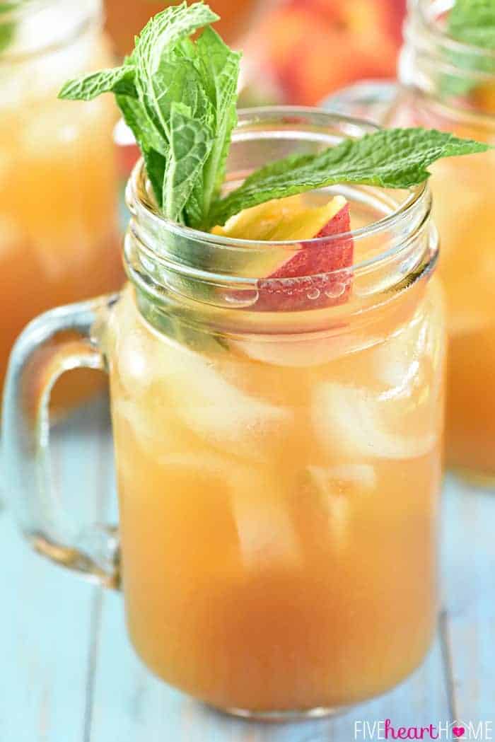 Glass of Peach Tea Punch with fresh mint and peach slice garnish.