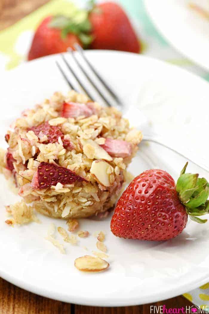 Strawberry Baked Oatmeal on white plate with fork and whole strawberry.