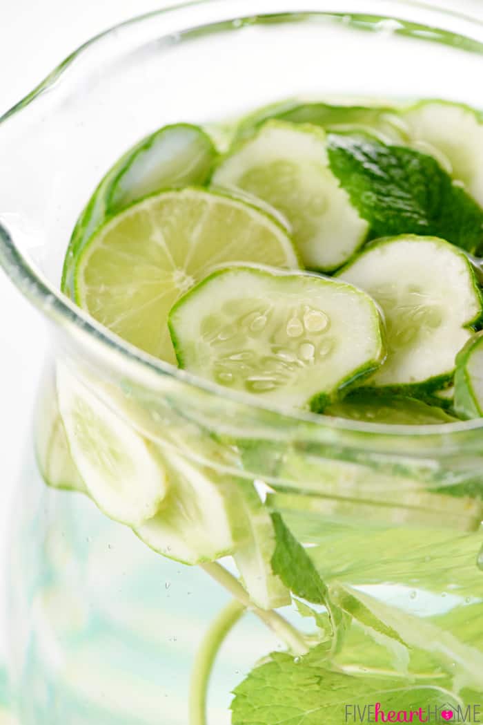 Cucumber Water with mint, limes, and cucumber slices floating in pitcher.