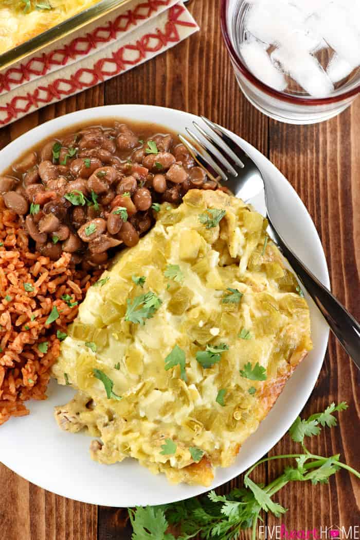 Aerial view of Chicken Enchilada Casserole on plate with rice and beans.