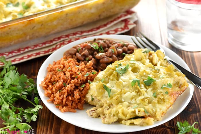 Chicken Enchilada Casserole on a plate with rice and beans.