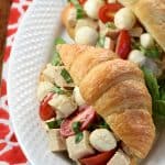Aerial view of Caprese Chicken Salad in croissants on plate.