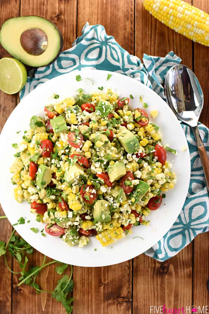 Aerial view of bowl of Corn Tomato Avocado Salad on white platter.