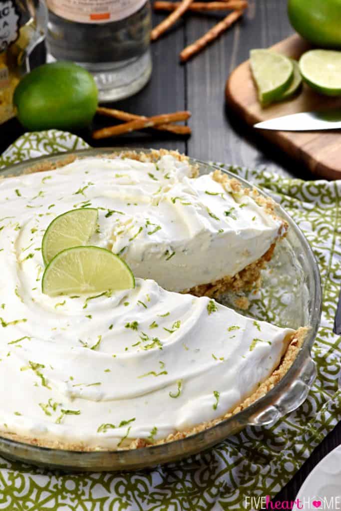 Frozen Margarita Pie on table with pretzels and limes.