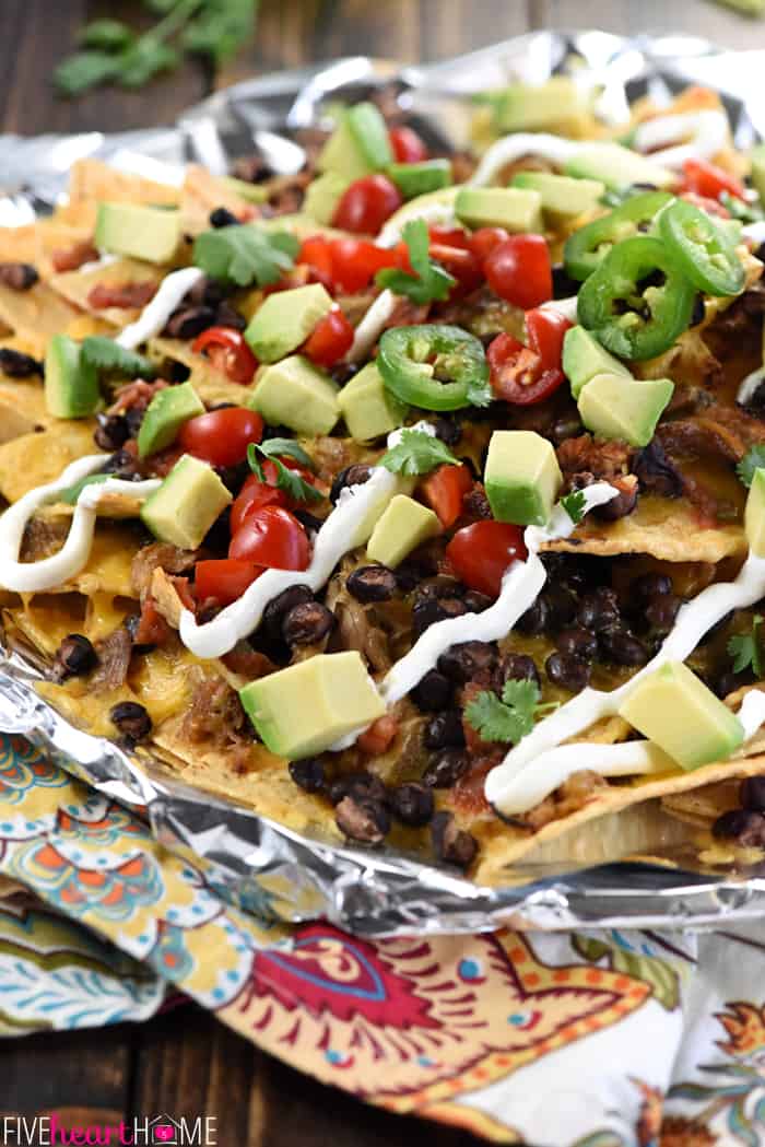 Piled high on a bed of tortilla chips for nachos.