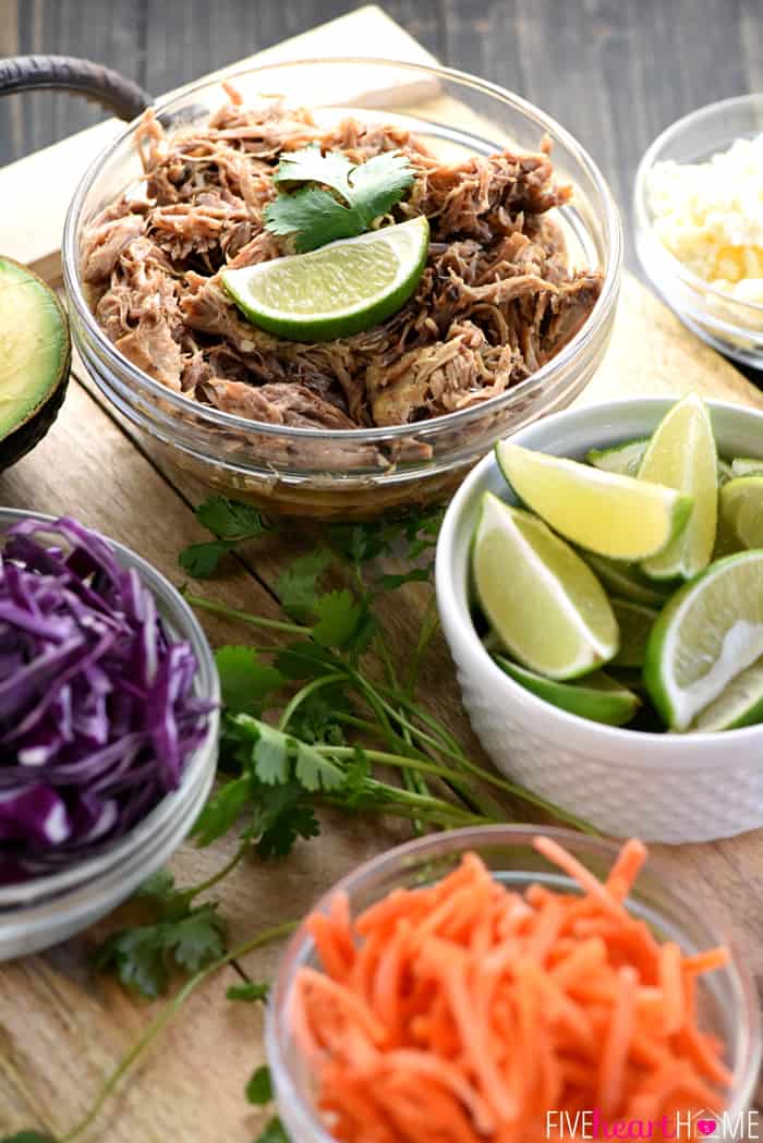 Bowls of pulled pork and various taco toppings.