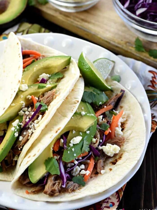 Slow Cooker Honey Lime Pulled Pork Tacos ~ tender, spicy-sweet pork piled on flour tortillas and topped with red cabbage, carrots, avocado, cotija cheese, and fresh cilantro for an easy, effortless dinner...and the leftover pork is fantastic on nachos! | FiveHeartHome.com