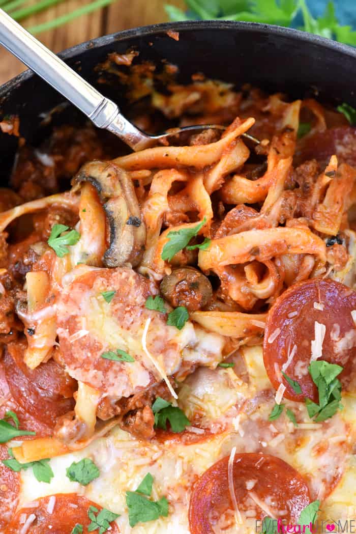 One-Pot Pizza Pasta ~ an easy, cheesy, comforting dinner recipe loaded with flavor thanks to all of your favorite pizza toppings...and as a bonus, everything gets cooked in the same pot! | FiveHeartHome.com Close-up of serving spoon taking a scoop.