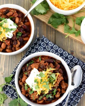 Slow Cooker Beefy Three-Bean Chili ~ a chunky, hearty, flavorful bowl of crock pot comfort food goodness, easy to adjust to your preferred spice level and delicious topped with sour cream, shredded cheese, and fresh cilantro! | FiveHeartHome.com