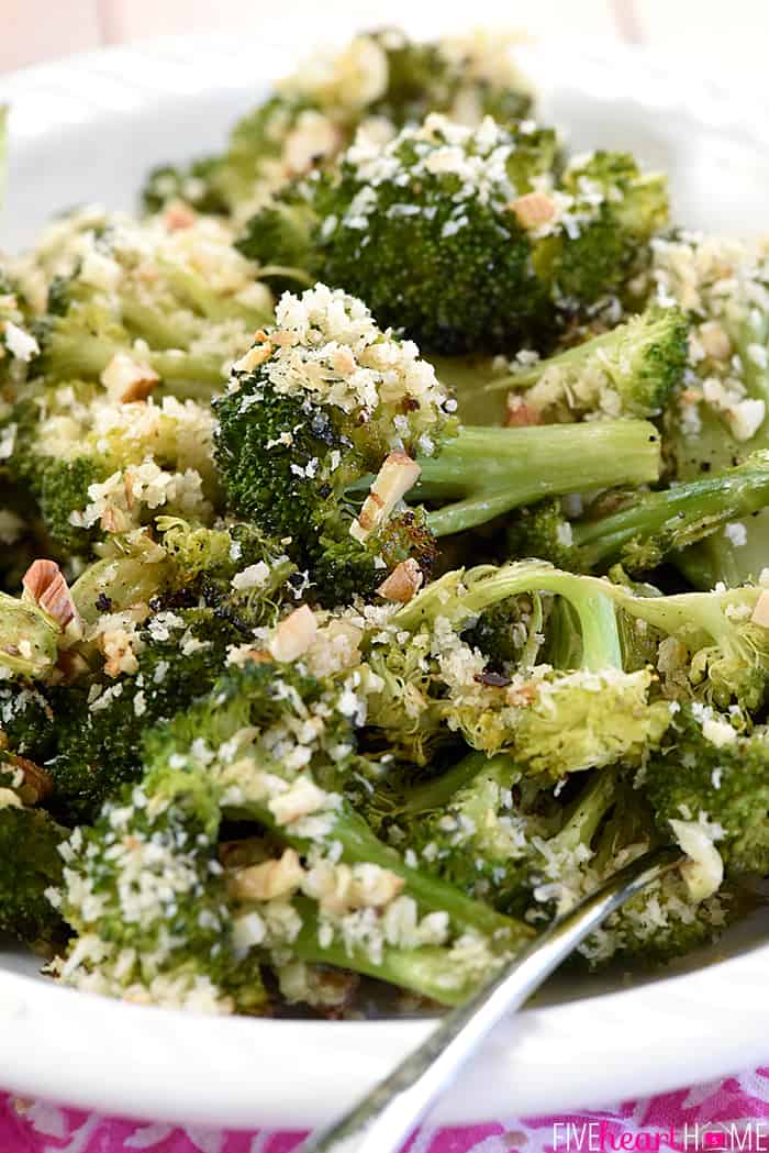 Close-up of Roasted Broccoli in a serving dish, topped with Parmesan, breadcrumbs, and pecans