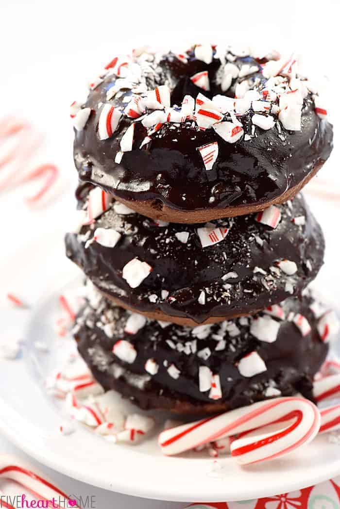Stack of Three Chocolate Peppermint Baked Donuts on White Plate with Peppermint Candy Canes on Plate