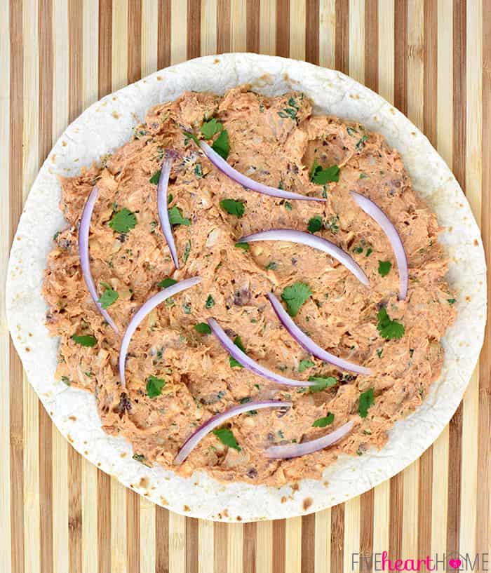 Tortilla spread with filling and ready to roll up.