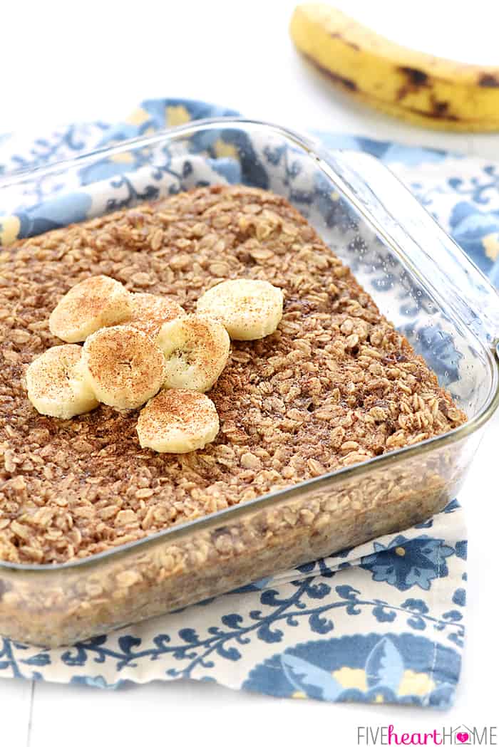 Banana Baked Oatmeal in square glass baking dish with sliced bananas and cinnamon on top.