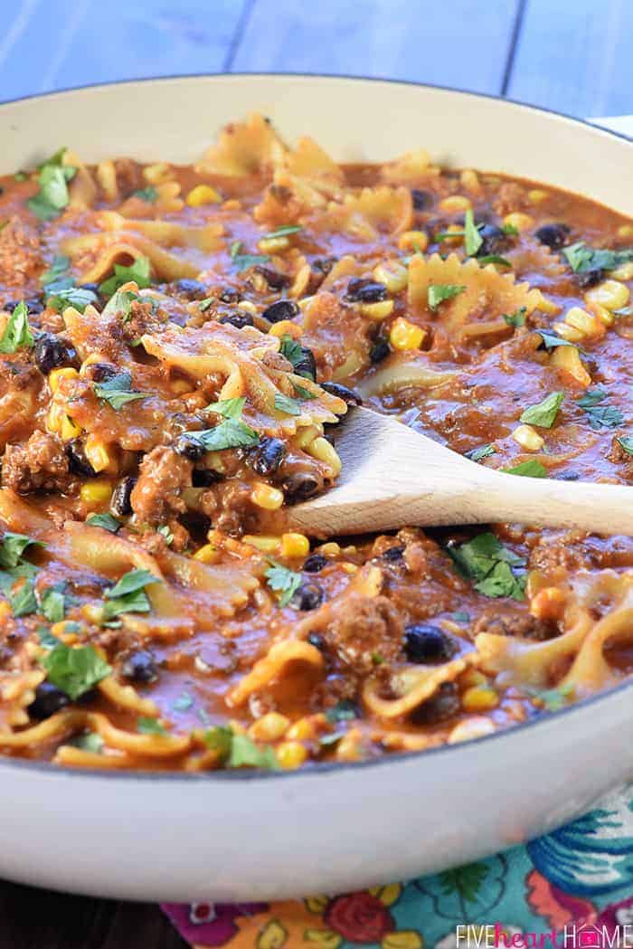 Taco Pasta in skillet with wooden spoon.