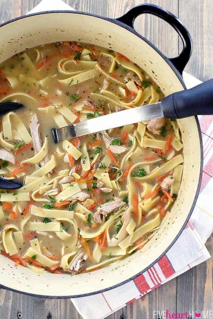 Aerial view of pot of Easy Chicken Noodle Soup with ladle.