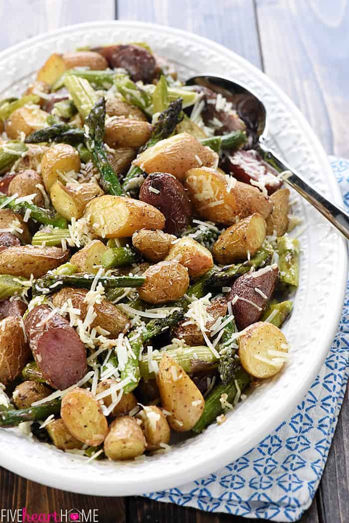 Roasted Potatoes and Asparagus on serving platter with a spoon.