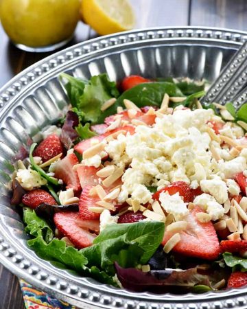 Easter Salad ~ this gorgeous Strawberry Goat Cheese Spring Greens Salad with Toasted Almonds & Lemon Honey Vinaigrette is loaded with vibrant colors and flavors and contrasting textures. It would be the perfect addition to your Easter holiday table, or it would make any dinner special! | FiveHeartHome.com