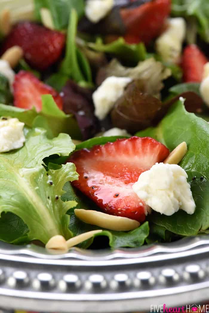 Close-up of ingredients including strawberries, goat cheese, and slivered almonds.