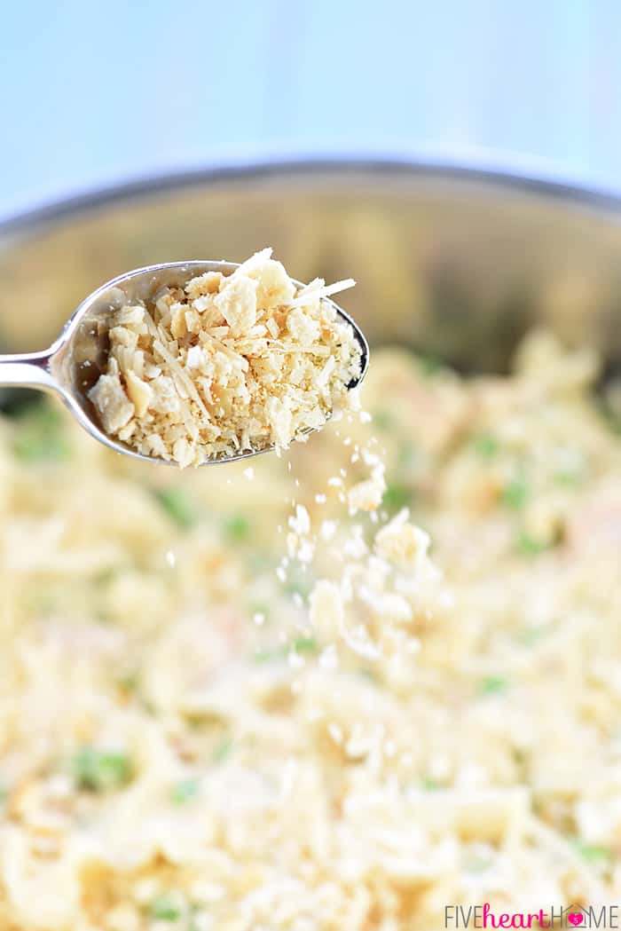 Cracker crumbs being sprinkled over skillet with a spoon.