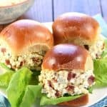 Egg Salad sandwiches with bacon and blue cheese on plate with lettuce.