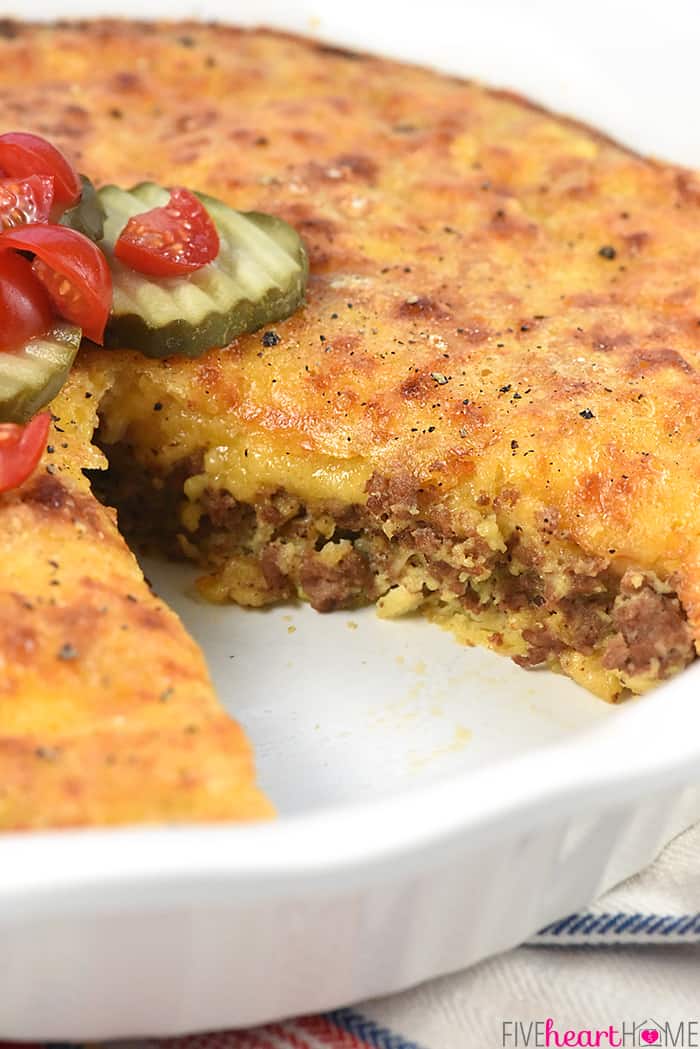 Slice missing from baking dish showing layers of ground beef, cheese, and crust