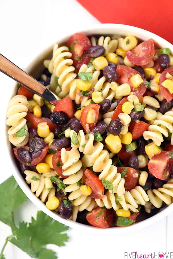 Fiesta Pasta Salad ~ this Mexican pasta salad is loaded with corn, black beans, tomatoes, jalapeño, cilantro, and a fresh lime vinaigrette for a zesty, flavorful, summer side dish! | FiveHeartHome.com Aerial View of Mexican Pasta Salad in bowl with spoon.