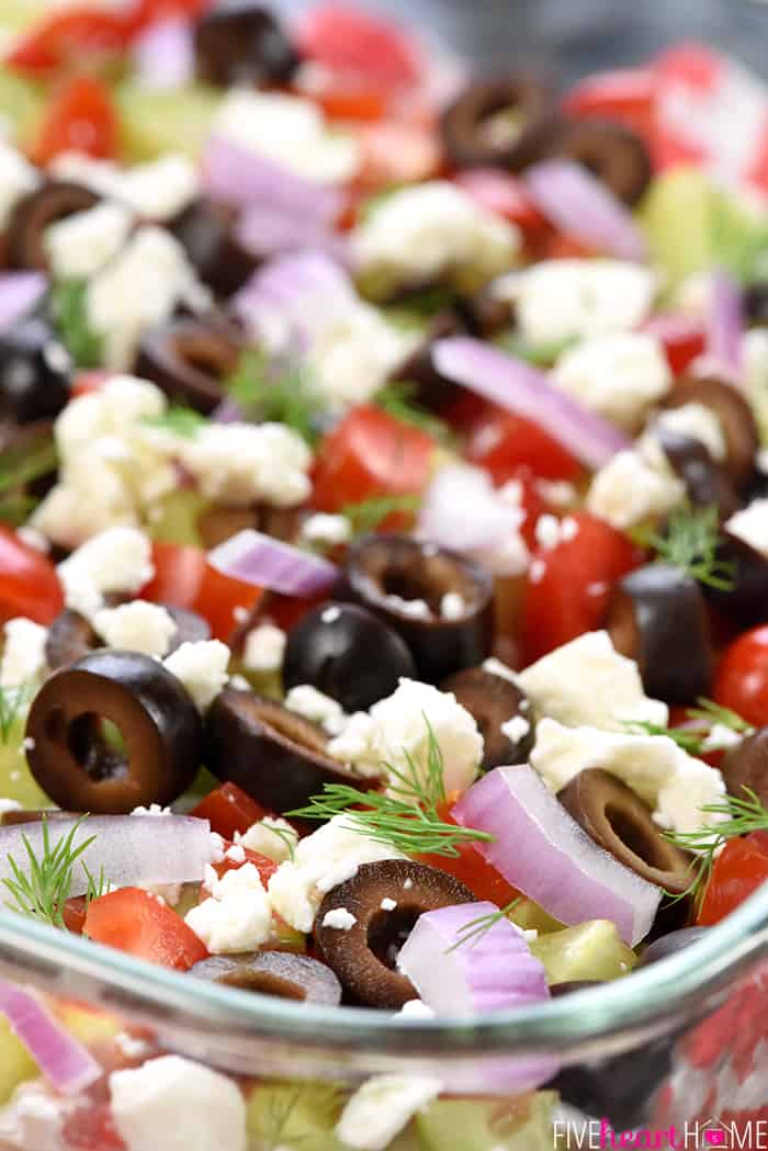 Greek 7-Layer Dip ~ a Mediterranean spin on the beloved, classic recipe, with layers of hummus, dill-infused Greek yogurt, tomatoes, cucumbers, black olives, red onion, and feta cheese! | FiveHeartHome.com Close-up of surface of Greek 7-Layer Dip.