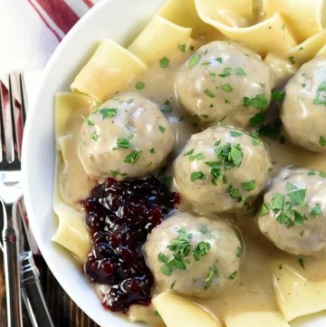 Swedish Meatballs ~ baked in the oven and then simmered in a skillet of creamy homemade gravy, this family-pleasing dinner recipe is both easy and delicious! | FiveHeartHome.com