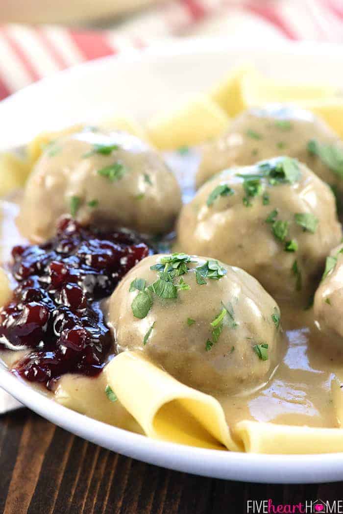 Close-up of Swedish Meatballs, egg noodles, and lingonberry jelly on a white plate
