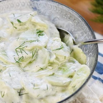 Ensalada de pepino alemana cremosa, AKA Gurkensalat ~ un plato de acompañamiento fresco y sencillo con pepinos en rodajas finas en un aderezo de crema agria y eneldo. ¡| FiveHeartHome.com