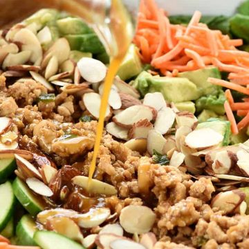 Dressing being poured over P.F. Chang's Chicken Lettuce Wraps Salad