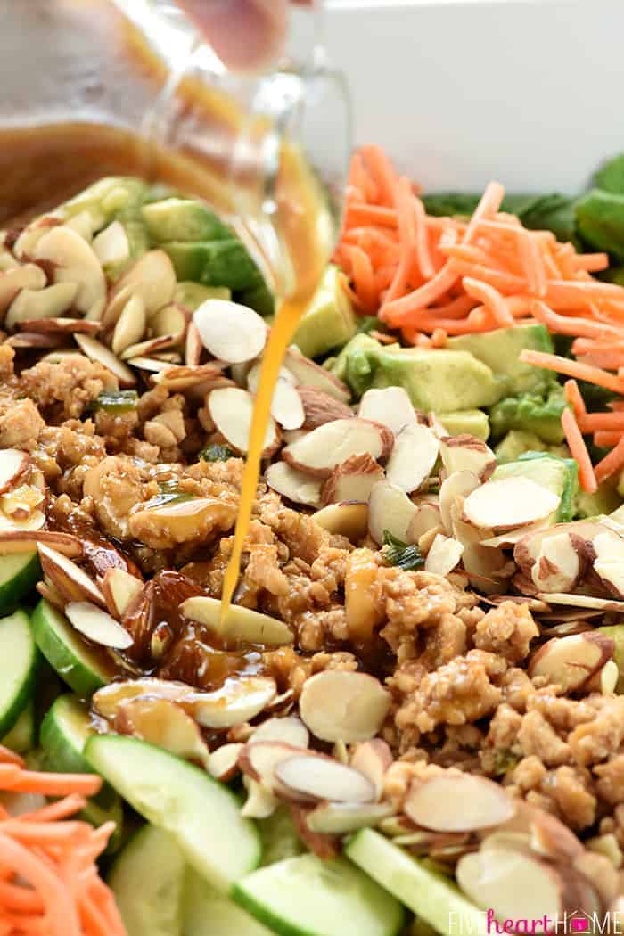 Salad dressing being poured over P.F. Chang's Chicken Lettuce Wraps Salad