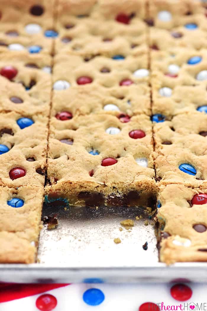 M&M Chocolate Chip Cookies Bars ~ these thick, chewy, big-batch treats are simple to make, fun to share, easy to customize with different colored M&Ms, and always a huge hit! | FiveHeartHome.com Cookie Bars in pan with one serving removed.