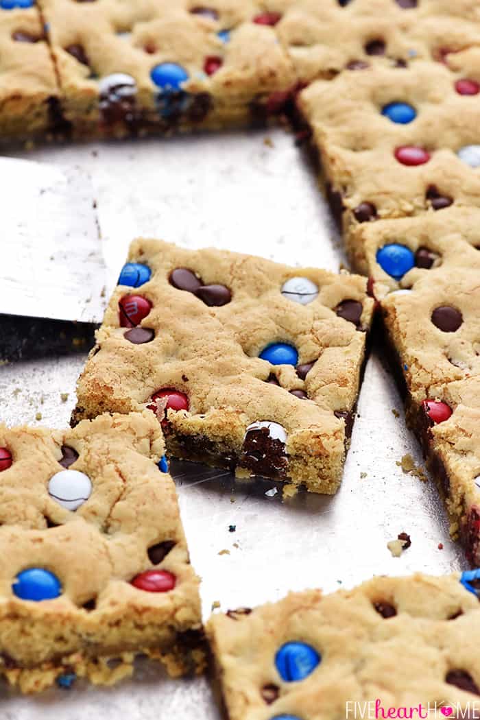 M&M Chocolate Chip Cookies Bars ~ these thick, chewy, big-batch treats are simple to make, fun to share, easy to customize with different colored M&Ms, and always a huge hit! | FiveHeartHome.com M&M Chocolate Chip Cookies Bars being removed from pan.