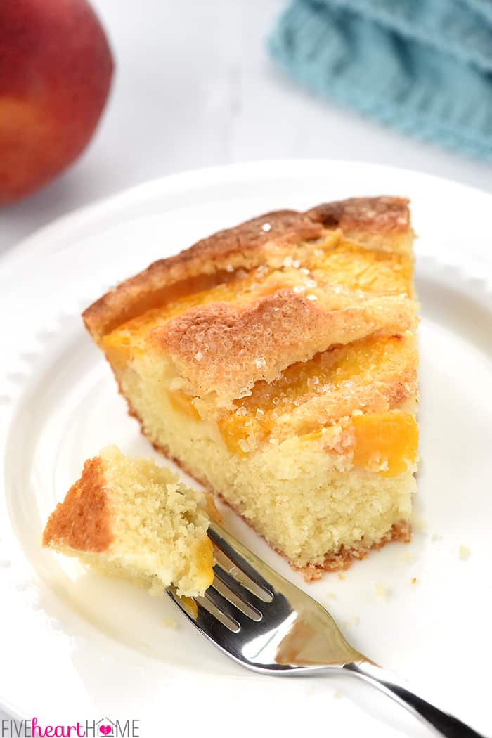 Fork removing a bite of slice of Peach Cake.