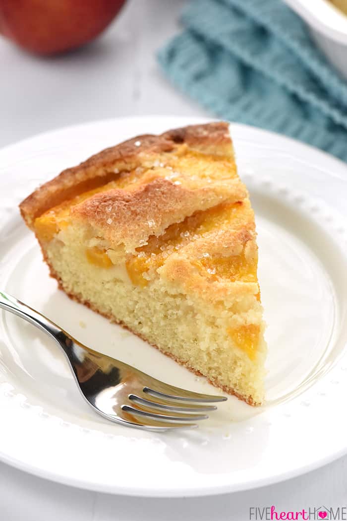 Slice of Summer Peach Cake on white plate with fork.