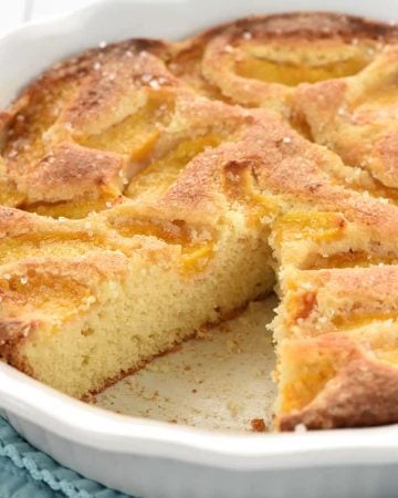 Summer Peach Cake in dish with missing slice.