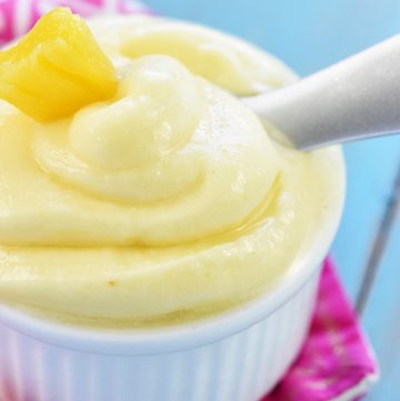 Pineapple Whip recipe in white bowl with spoon and garnish.
