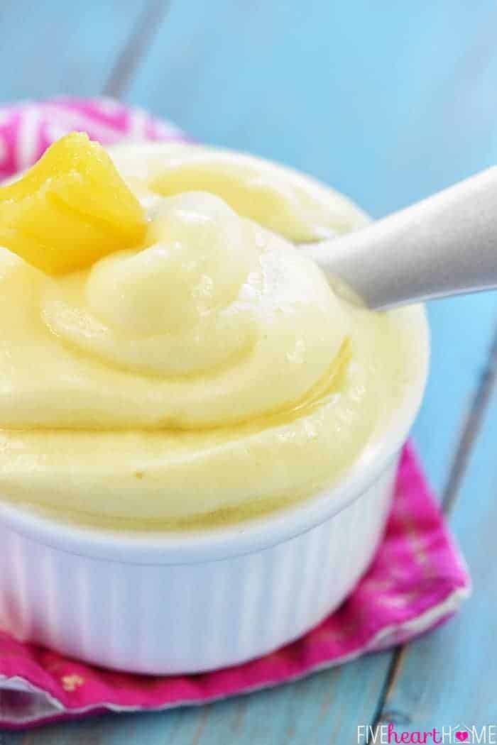 Close-up of Pineapple Whip in bowl with spoon and pineapple garnish.
