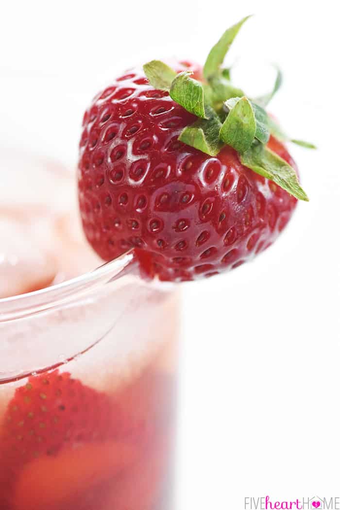 Strawberry Iced Tea ~ made with sweet, fresh, strawberry simple syrup for a refreshing summer drink! | FiveHeartHome.com Whole strawberry garnish on rim of glass of tea