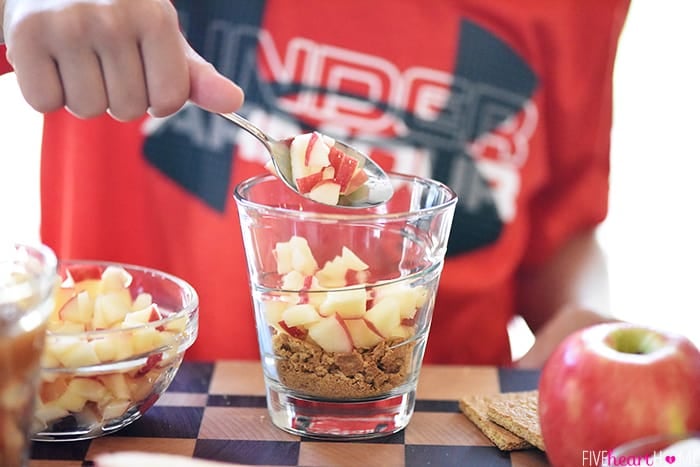 Diced Apple being Scooped into Pie Snack Cups by Reid