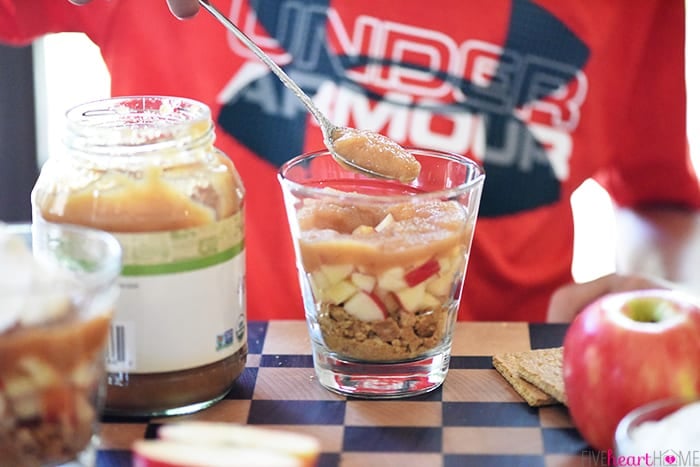 Applesauce Layer being Added into Healthy Apple Pie Snack Cups 