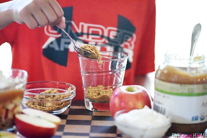 Healthy Apple Pie Snack Cups ~ layers of graham cracker crumbs, diced apples, cinnamon applesauce, and whipped cream make a wholesome after-school snack or dessert that tastes just like apple pie! | FiveHeartHome.com Reid Creating Layers in Cup