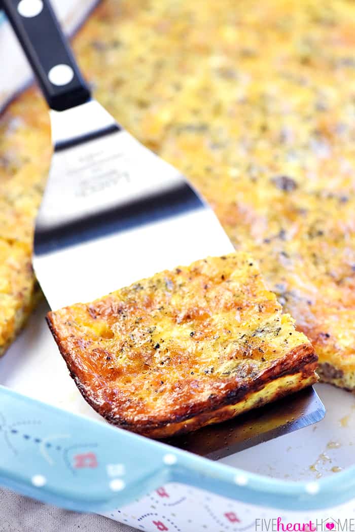 Slice of ground beef breakfast recipe being lifted out of baking dish by spatula.