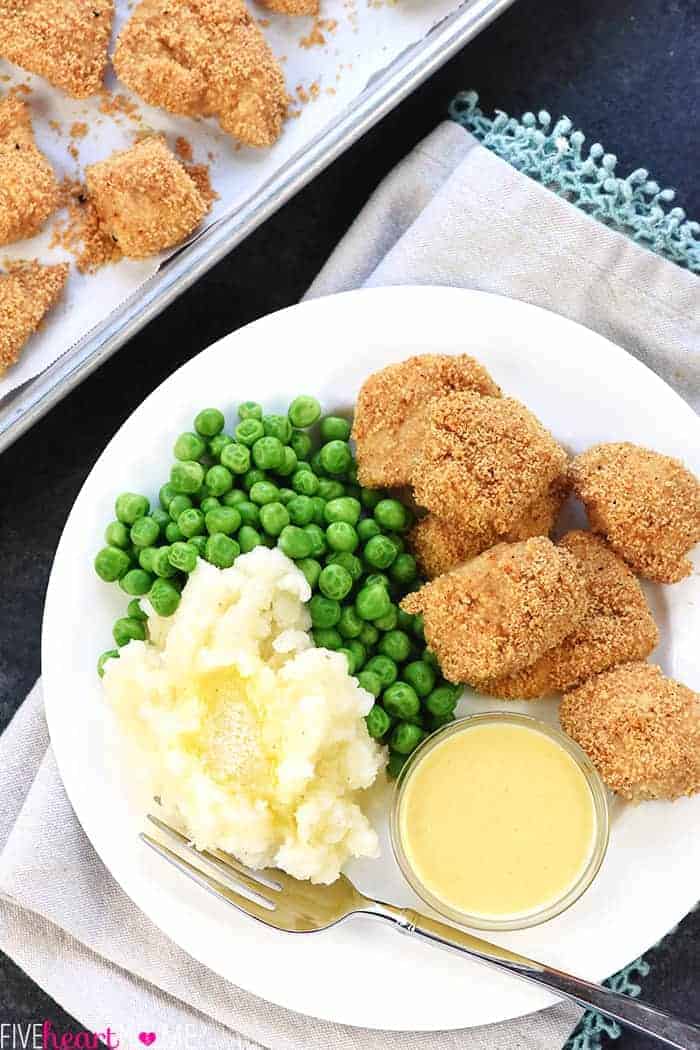 Aerial view on white plate with peas, mashed potatoes, and dipping sauce.