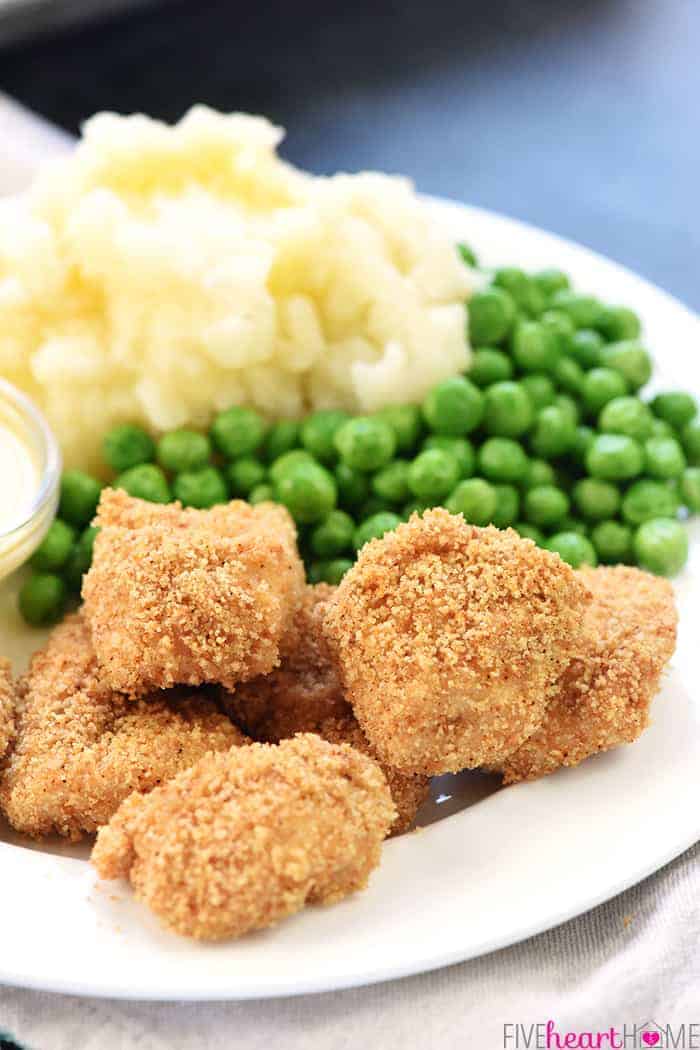 Homemade Chicken Nuggets ~ this recipe is made the QUICK AND EASY way, with a copycat "shake n bake" method yielding effortless, tasty nuggets that are a hit with kids and adults alike! | FiveHeartHome.com Close-Up of Copycat Shake and Bake Chicken Nuggets with mashed potatoes and peas
