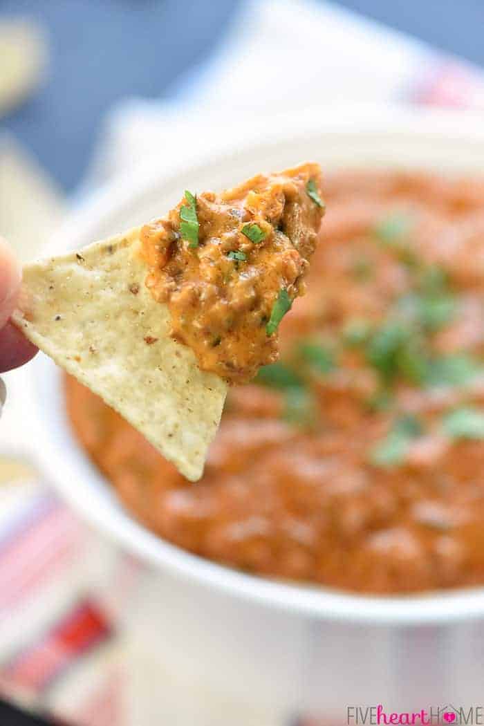 Hot Taco Dip scooped up by a tortilla chip.