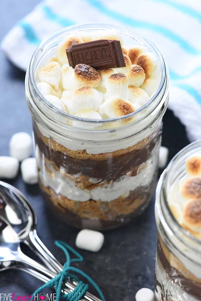 Mini S'mores Trifles ~ layered with rich chocolate pudding, crushed graham crackers, and marshmallow-laced whipped cream for a simple, yummy, no-bake dessert! | FiveHeartHome.com Mini S'mores Trifles garnished with mini marshmallows and Hershey's squares.